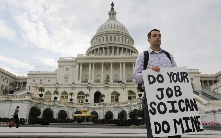A furloughed federal employee holds a sign on the steps to the U.S. Capitol in Washington Oct. 1 after the U.S. Government shutdown. This is the first time the government has shut down in nearly 18 years. (CNS photo/Larry Downing, Reuters) (Oct. 1, 2013) See SHUTDOWN-LEADERS Oct. 1, 2013.